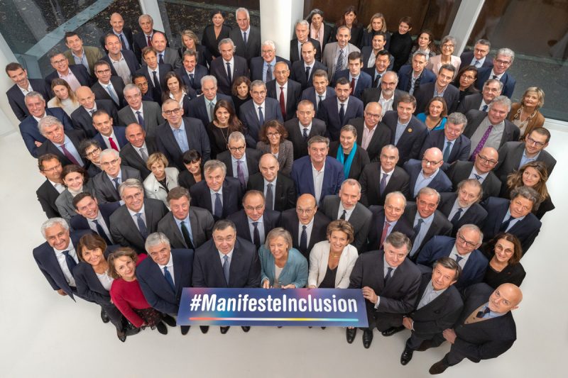 Les adhérents du #ManifesteInclusion sont regroupés. Photo prise de haut avec un panneau représentant le nom de l'association