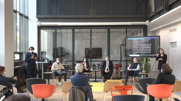 Photo de Groupe de Travail 5 participants accompagnés d'un écran de vélotypie et d'une interprète en LSF (langue des signes française)